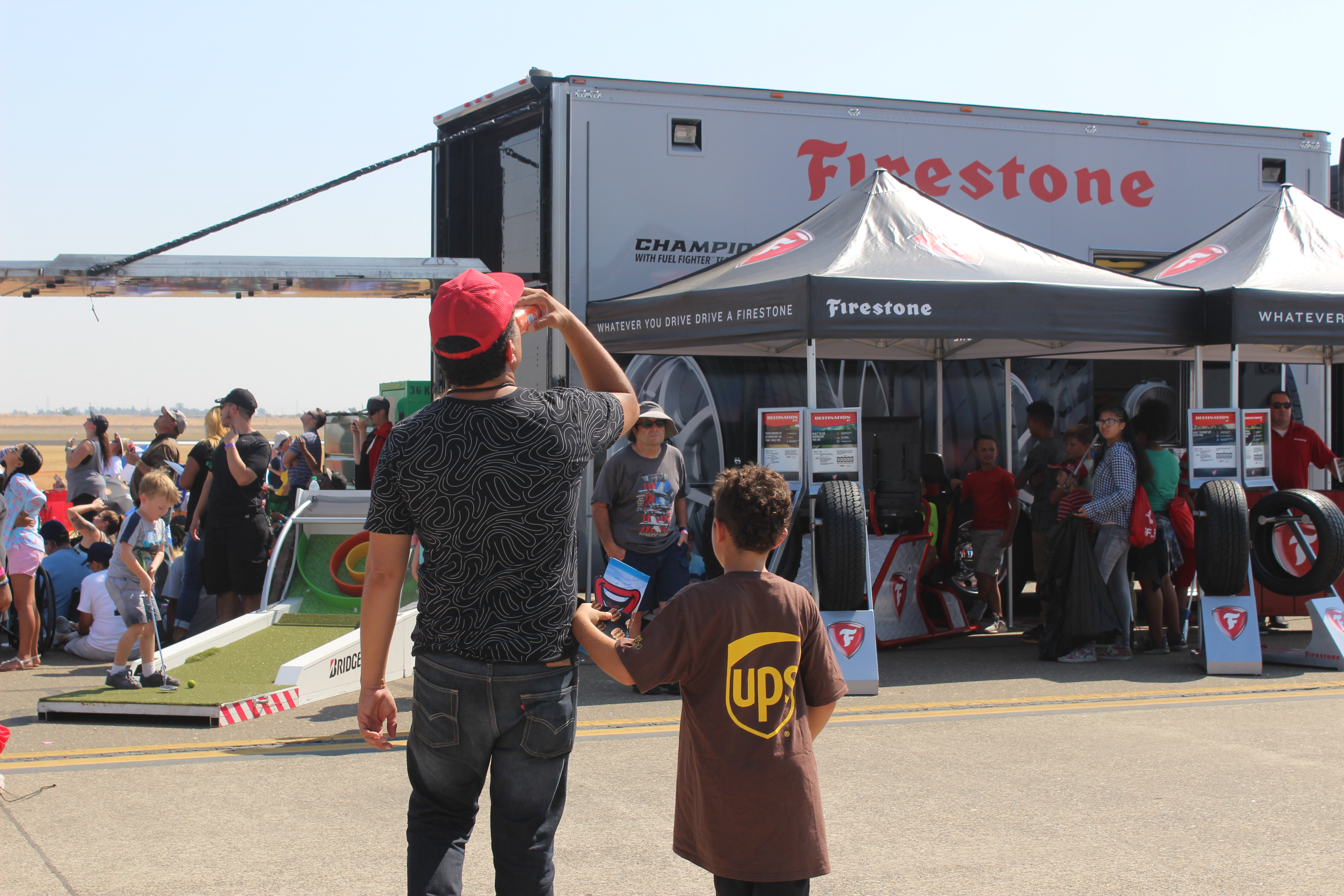 Dad and son standing in front of a Firestone Tire exhibit at an air show