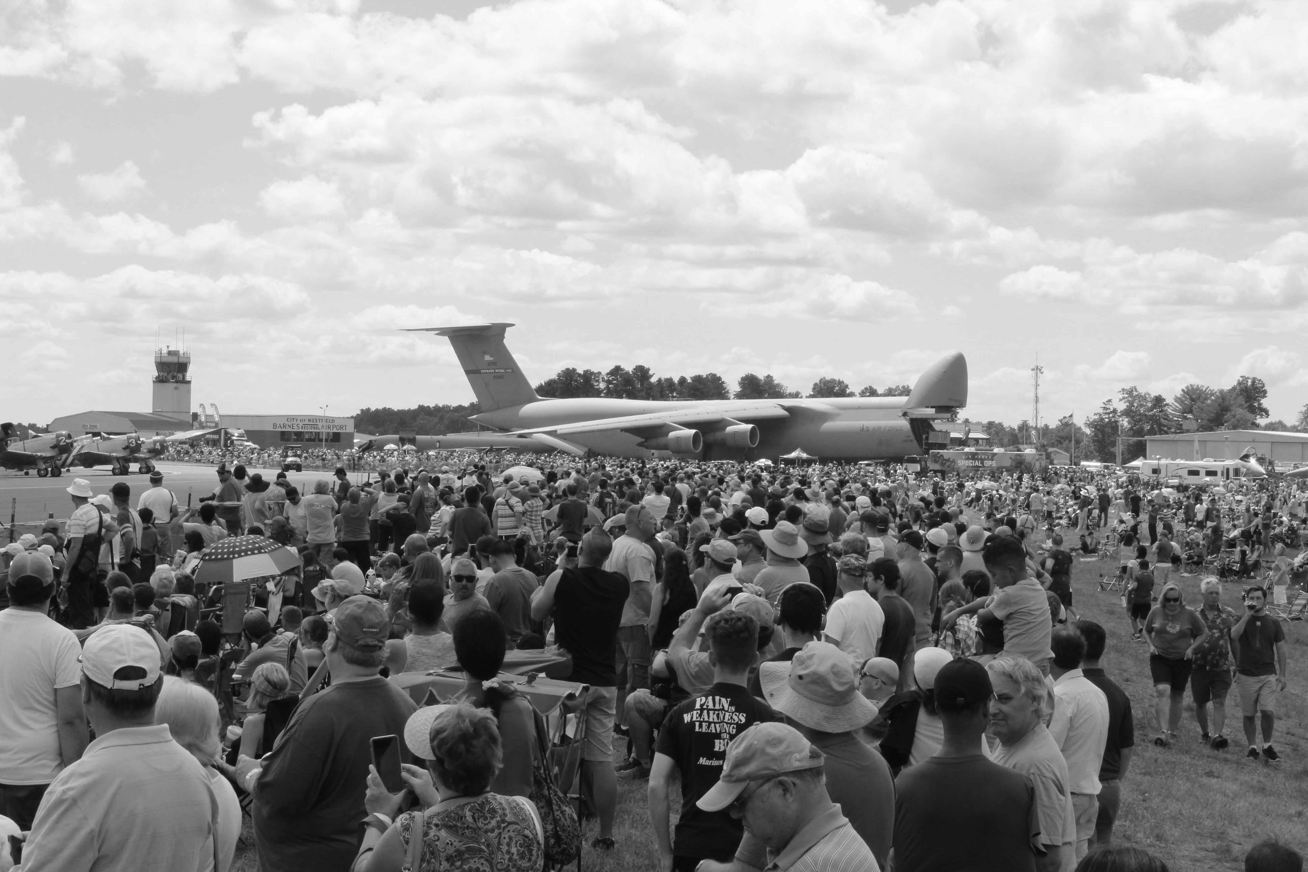 black and white image of an air show crowd with a C5 military plane in center background