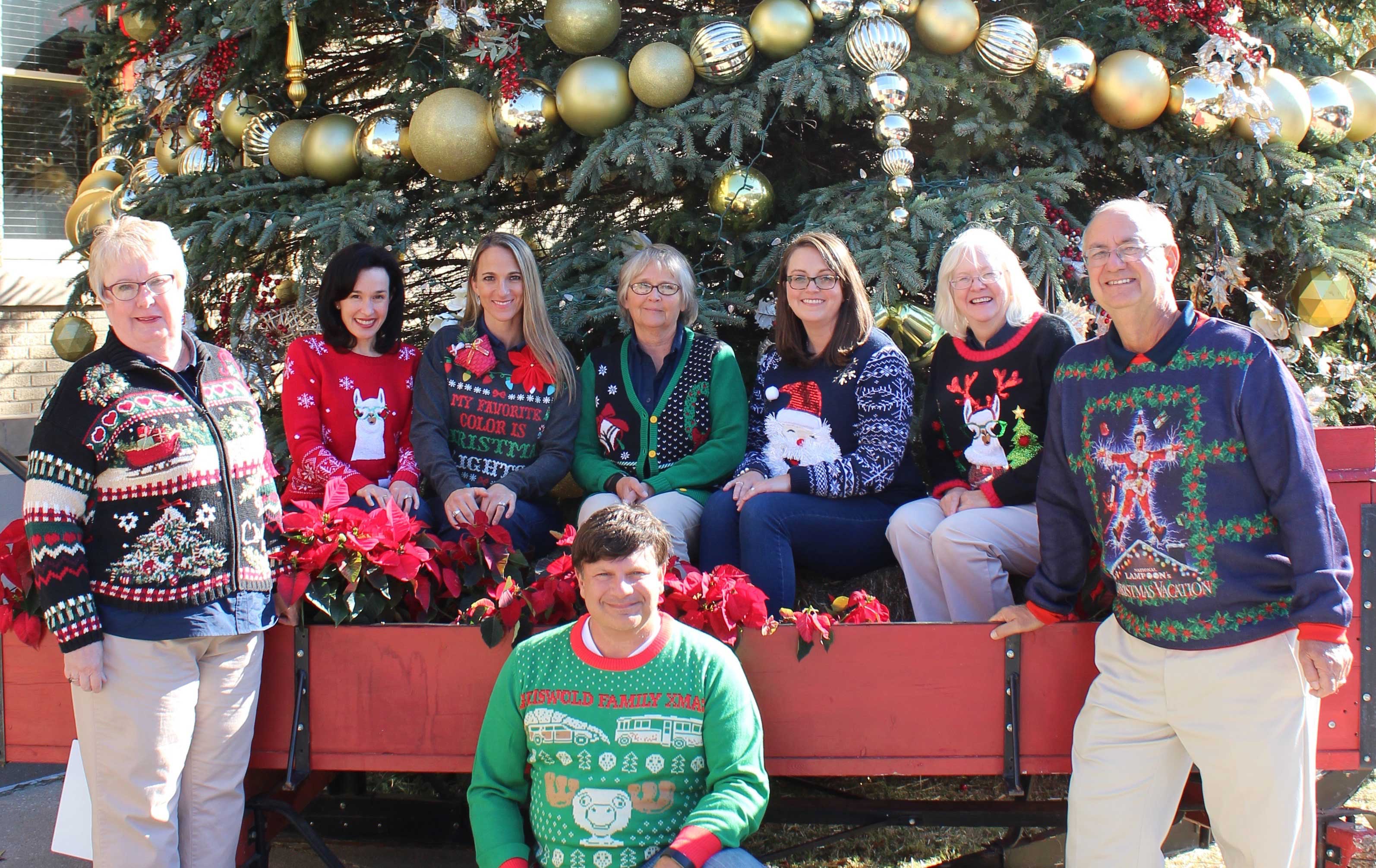 adc group team posing in christmas sweaters