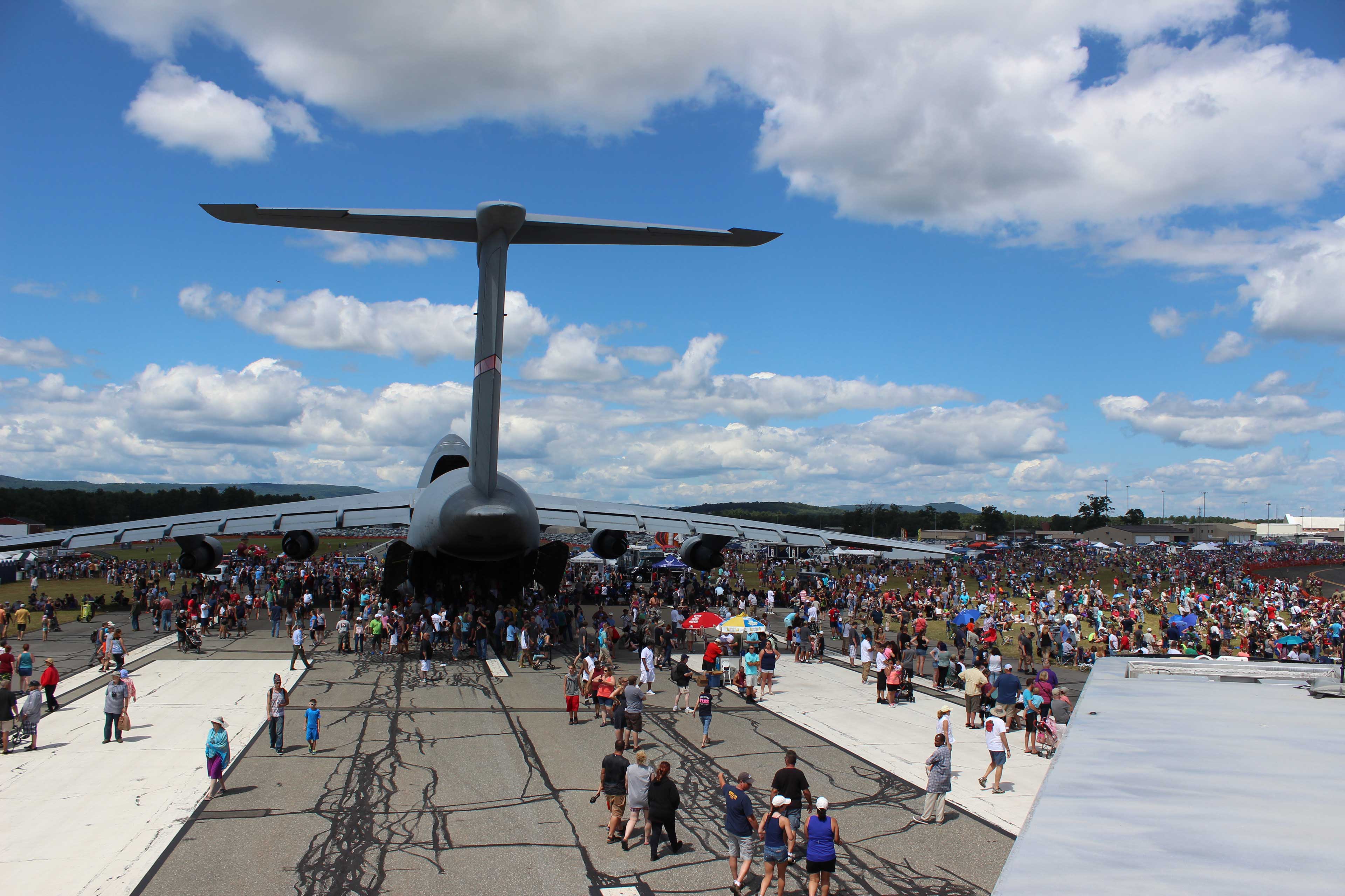 C5 airplane surrounded by crowd at an air show on a beautiful day