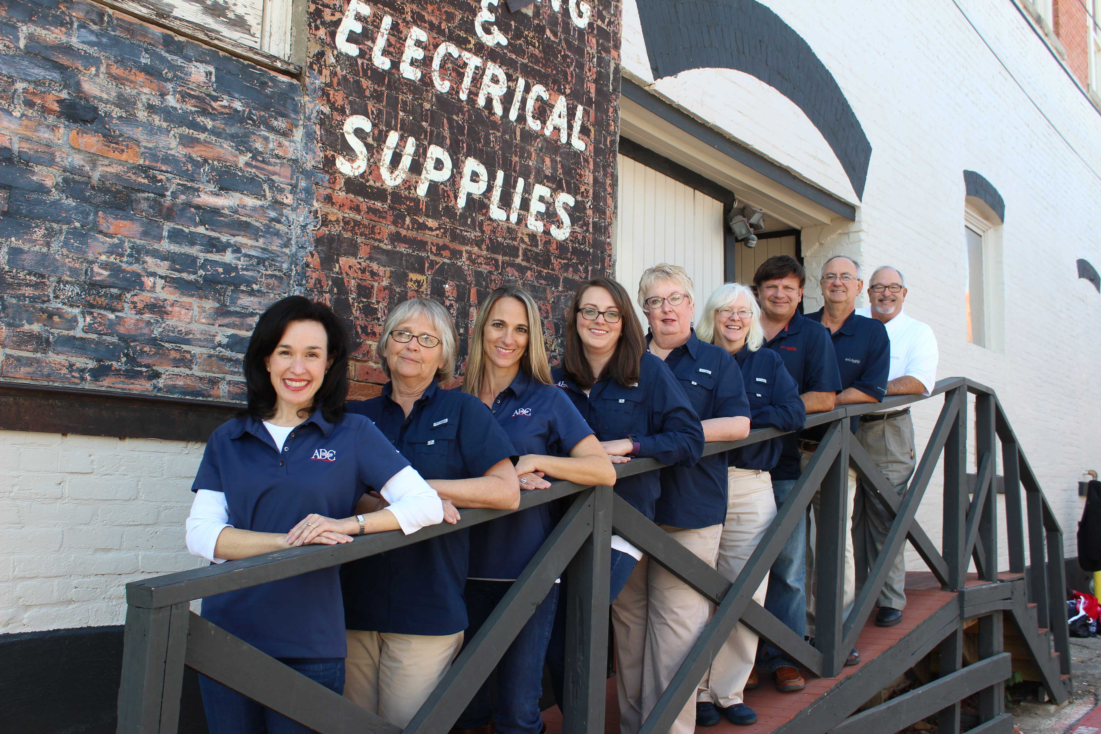 ADC Group team posing in front of a building